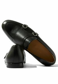 Crne kožne loafers cipele s dvostrukim kopčama, glatkom teksturom, šiljastim vrhom i elegantnom siluetom s niskom petom.