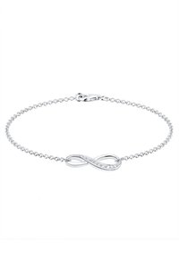 Silver kedja armband med en oändlighetssymbol som har en rad små klara ädelstenar längs kurvan. Karbinhake avslutning.