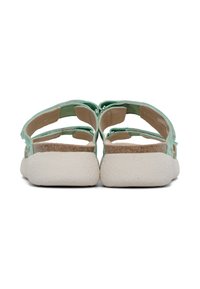 Sandali in tessuto verde con cinturini regolabili, suole in sughero e suole in gomma bianca testurizzata, mostrati da una vista posteriore con dettagli minimi.