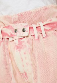 Pantalones cortos de tela tie-dye rosa con cinturilla texturizada, dos botones metálicos y un cinturón estructurado con trabillas.