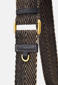 Cintura a trama herringbone nera e marrone con anello rettangolare dorato e dettagli in D-ring dorati, accentuata da linguette in pelle nera con cuciture.