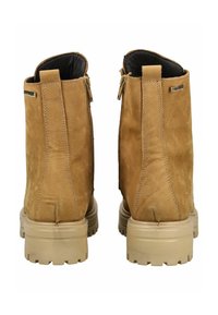 Brown suede ankle boots with a textured finish, featuring a side zipper and a chunky rubber sole with a patterned tread.