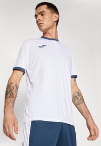 Short-sleeve white athletic shirt with navy collar and sleeve accents, featuring breathable fabric and a small logo on the chest.