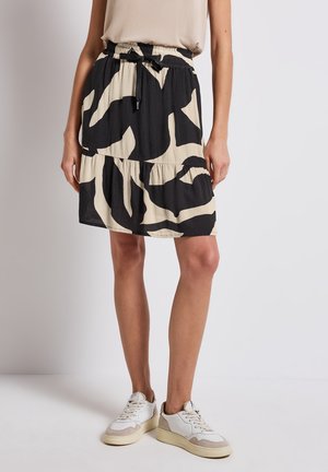Sort og beige flæset nederdel med et dristigt abstrakt mønster, elastisk taljebånd med snøre og et let, tekstureret stof.