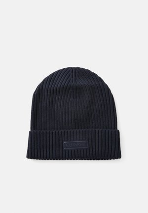 Cappello lavorato a maglia navy con texture a costine e risvolto. Presenta una patch rettangolare con il logo Calvin Klein sul davanti.