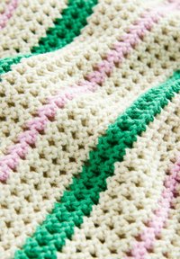 Crocheted textile in cream with vertical stripes of light pink and green. Features a textured, open stitch pattern. Soft, flexible material.