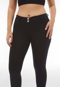 Sorte leggings med en glat tekstur, to knapper foran og sidelommer. Taljebåndet har stropper til et bælte.