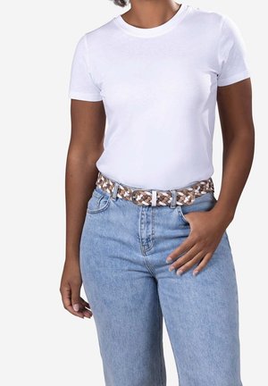 Person wearing plain white short-sleeve t-shirt, light blue high-waisted jeans, and a brown and white woven belt, hand in pocket.