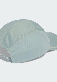 Gorra deportiva de color azul claro con una tela texturizada, visera curvada y correa ajustable. Presenta un diseño sin costuras y costuras reforzadas.