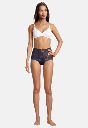 Weißes Bralette und navyblaue Spitzen-Hüfthöschen. Die Höschen verfügen über florale Spitzenmuster mit einem gewellten Rand.