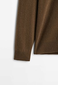 Manche de pull marron en tricot avec poignet et ourlet côtelés, présenté sur un fond blanc.