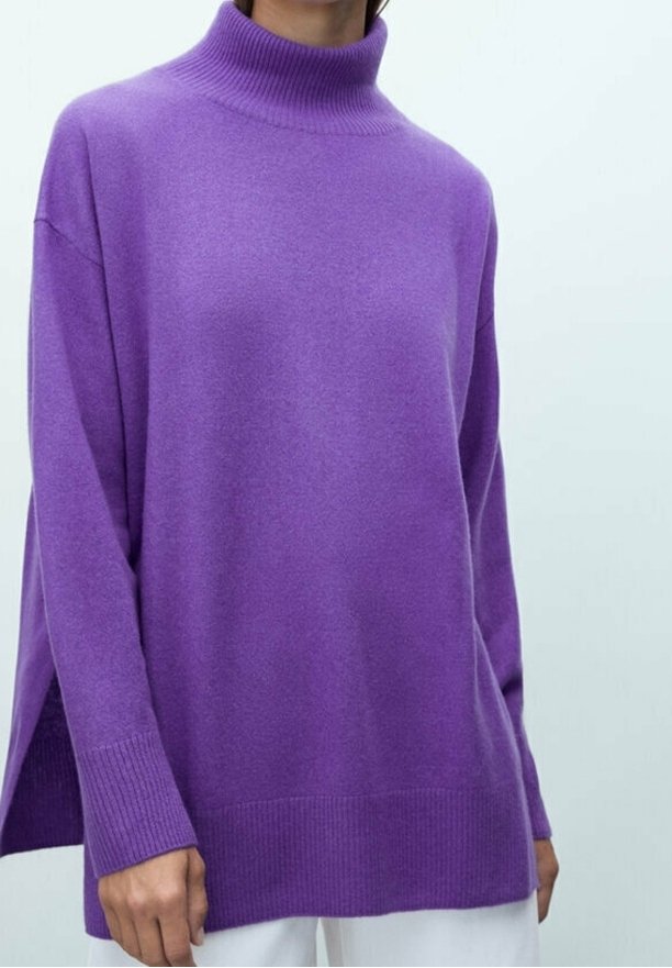 Purple turtleneck sweater with a loose fit, ribbed cuffs, and side slits, made from soft material with a smooth texture.