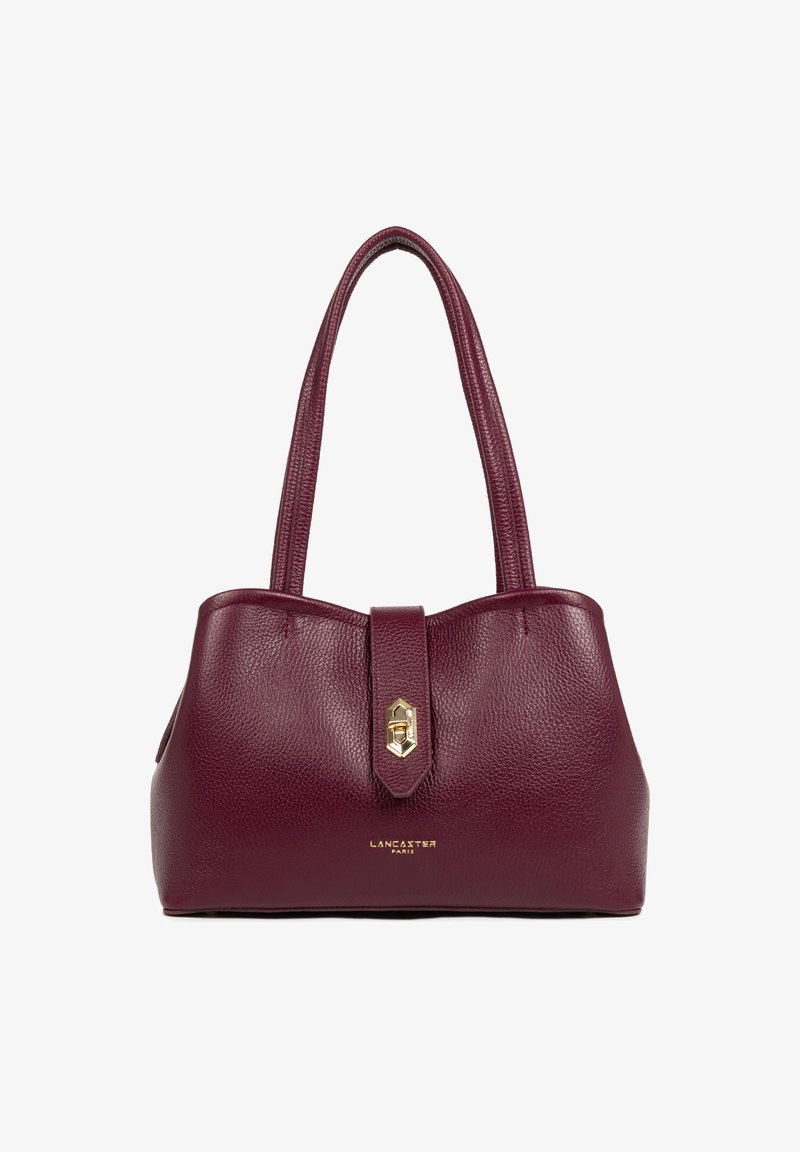 Sac à main en cuir bordeaux avec surface texturée, double poignées courtes, quincaillerie dorée et fermeture à clasp à l'avant. Étiquette de marque visible.