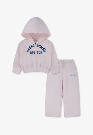 Sweat à capuche rose clair pour enfants avec fermeture éclair et pantalon assorti, tous deux avec le logo bleu Abercrombie & Fitch.