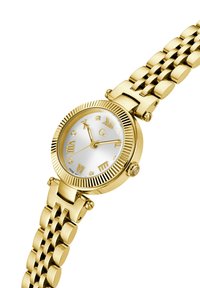 Orologio in metallo dorato con bezels a coste, quadrante bianco, indicatori in numeri romani e accenti scintillanti. Presenta uno stile di bracciale a maglie.