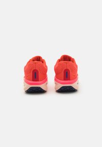 Sportliche Schuhe aus leuchtendem Korallenmesh mit gepolstertem Fersenbereich, kontrastierender pinker Zwischensohle und strukturiertem navy-blauen Gummisohle. Glattes Innenfutter.