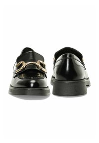 Scarpe in vernice nera con punta arrotondata, dotate di un accento in catena dorata e una suola nera bassa e testurizzata. Finitura liscia senza motivi.