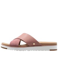 Pink leather slide sandals with a suede accent, featuring a cross strap design and a white, textured sole for grip.