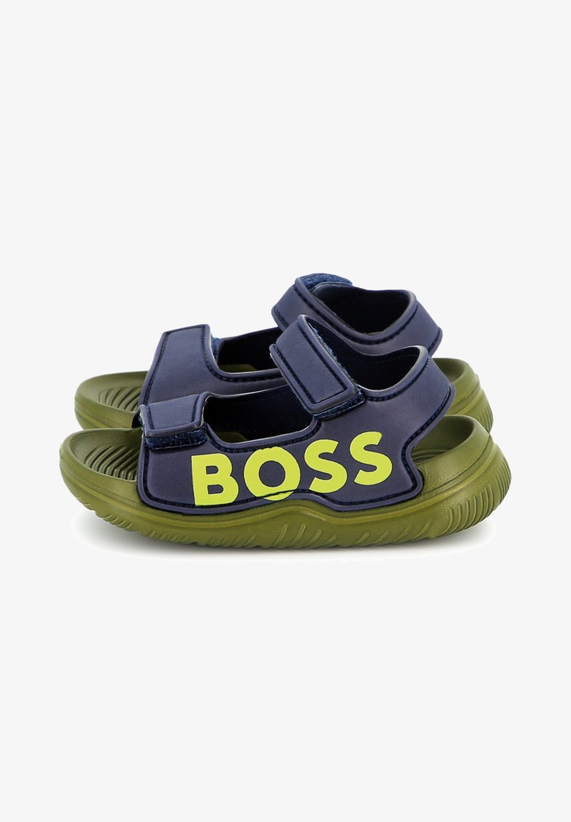 Marinblå sandaler med gröna gummisulor har justerbara remmar och djärv gul "BOSS"-logotyp på sidan. Texturerad fotbädd för bra grepp.