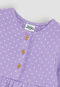Fialové bavlnené šaty s bielymi bodkami, s okrúhlym výstrihom a tromi drevenými gombíkmi. Rozšírený lem s naskladanými detailmi.