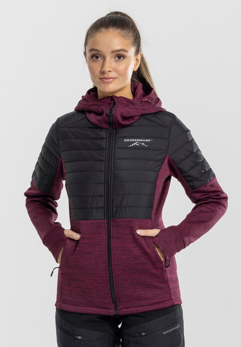 Black and dark red zip-up jacket with quilted panels, front pockets, and adjustable hood. Features logo on chest and textured fabric.