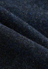 Dunkelblaues, strukturiertes Material, das eine Mischung aus Fasern aufweist, mit einer weichen, flauschigen Oberfläche. Das Material zeigt subtile Farbvariationen.
