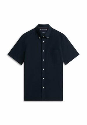 Camicia blu navy a maniche corte con bottoni, colletto e taschino sul petto con un piccolo logo a bandiera rosso, bianco e blu.