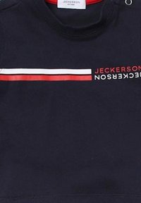 Felpa blu navy con accentuazione rossa attorno al colletto, caratterizzata da una grafica orizzontale a righe bianche e rosse e testo del brand in bianco.