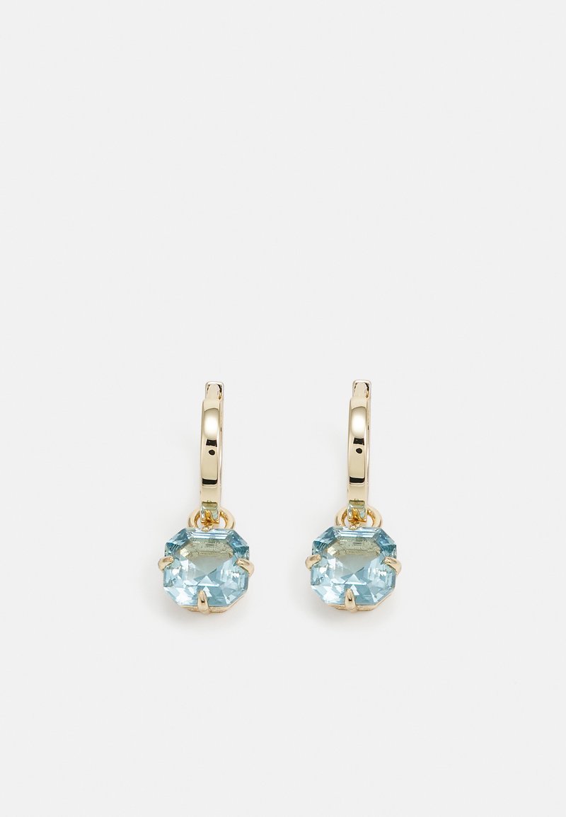 Brincos em forma de argola em tom dourado com cristais octogonais azul claro, apresentando seis garras segurando as pedras. Acabamento metálico liso e brilhante.