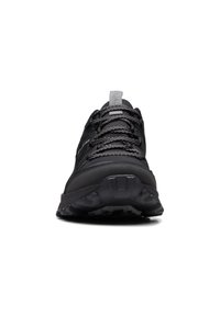 Zapatilla deportiva negra con parte superior texturizada, suela gruesa y cordones reflectantes. Cuenta con un cuello acolchado y una puntera reforzada.