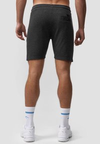Mørkegrå træningsshorts med en glat tekstur, der har en baglomme med knaplukning og er designet til at nå midt på låret.