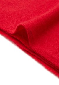 Rode wollen stof met een zachte textuur, met een gladde en licht fuzzy oppervlakte, gevouwen om de kleur en materiaalkwaliteit weer te geven.