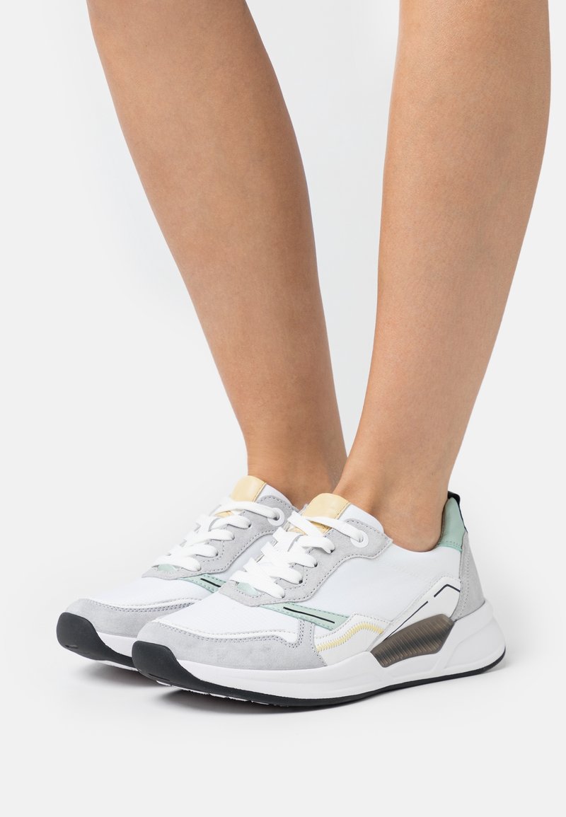 Bílé a šedé tenisky s semišovými akcenty, vybavené texturovaným designem, kulatou špičkou, šněrováním a měkkou podešví.