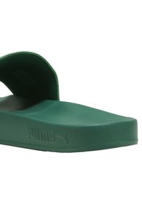 Sandale de bain verte en caoutchouc avec une semelle épaisse, dotée d'un footbed contourné et d'une bride arrière surélevée. Logo imprimé sur le côté.