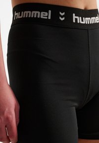 Czarne bokserki stretchowe z szerokim elastycznym pasem, na którym znajduje się logo "hummel" w odcieniu szarym. Materiał ma gładką teksturę i dopasowany krój.