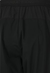 Svart träningsbyxor med ett elastiskt midjeband och en texturerad logotyp. Slät tyg med en strömlinjeformad passform, designad för komfort.