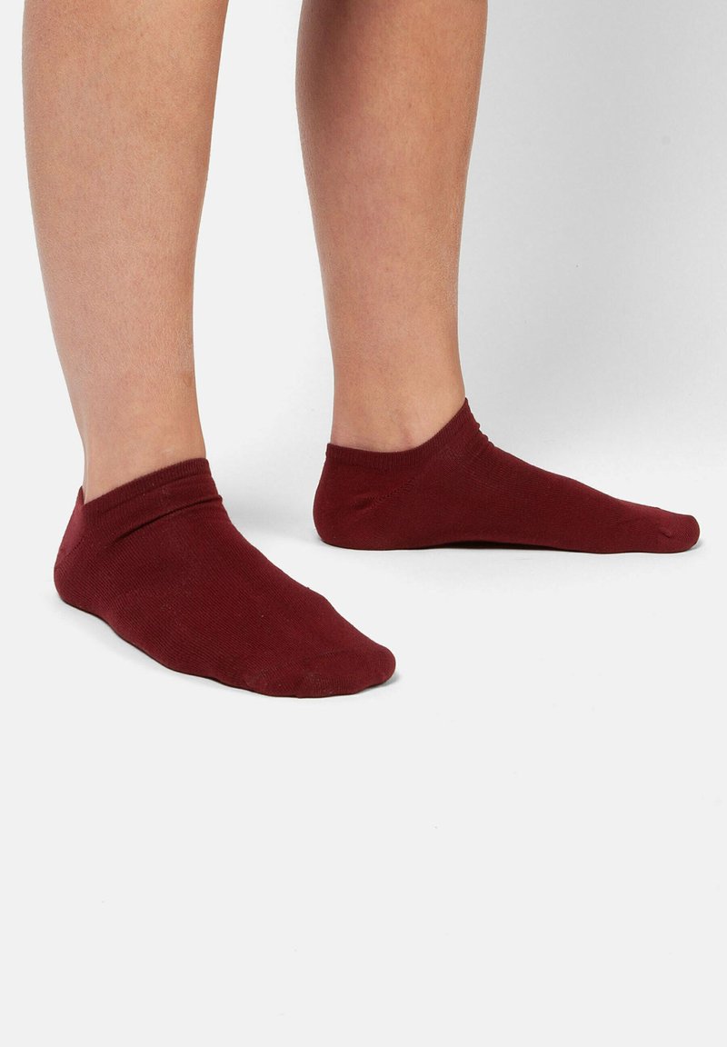Bordeaux ankelstrømper lavet af blødt stof, med en glat tekstur og et enkelt design, der dækker foden og anklen.