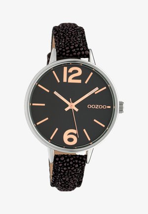 Montre avec bracelet en cuir noir texturé, cadran noir, aiguilles et index en or rose, et boîtier rond argenté affichant le nom de la marque "OOZOO".