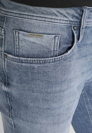 Nahaufnahme von einer hellblauen Jeanstasche mit einem kleinen Etikett, das "Antony Morato" über der Tasche aufgedruckt hat.