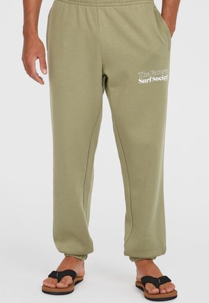 Olivgröna sweatpants med avslappnad passform, elastisk midja och samlade muddar. "The Future Surf Society" tryckt i vitt på vänster lår.