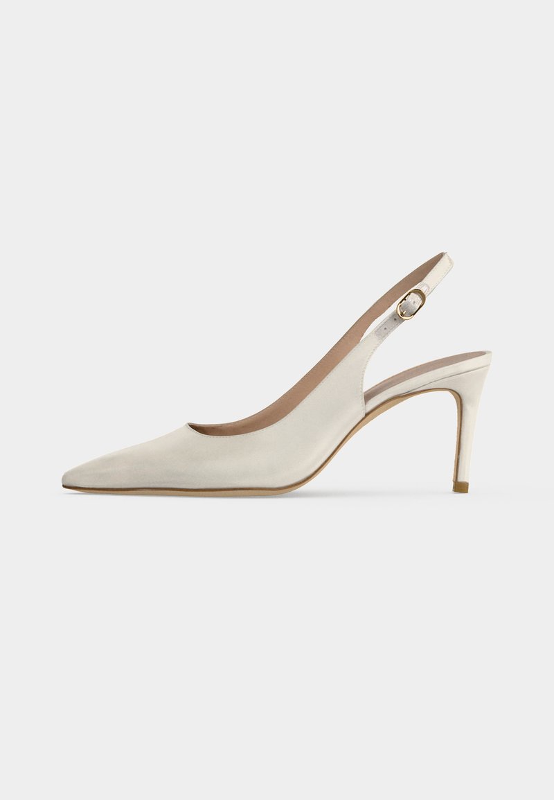 White leather slingback high heel shoe with pointed toe and buckle strap on plain background.