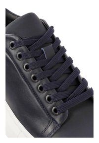 Sneaker in pelle blu navy con lacci piatti, occhielli in metallo e punta arrotondata. Presenta una suola testurizzata e un pannello della linguetta liscio.