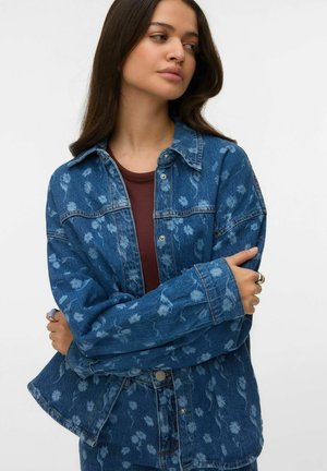 Niebieska kurtka dżinsowa z kwiecistym wzorem, zapinana na guziki, z kołnierzem i luźnym krojem. Miękka w dotyku, z długimi rękawami.