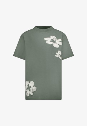 Groen katoenen t-shirt met korte mouwen, met grote witte bloemmotieven aan de voorkant. Eenvoudige, ronde hals stijl. Glad oppervlak.