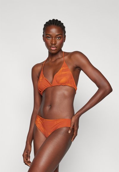 Oranžový bikiny s trojuholníkovým vrchom a jemným naberaním, s nastaviteľnými ramienkami, spárované s bikiny spodnou časťou s nízkym pásom. Hladká textúra.