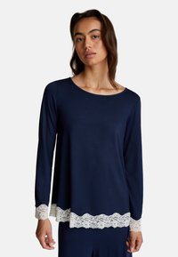 Maglietta a maniche lunghe blu navy realizzata in tessuto morbido, con un bordo di pizzo bianco a forma di scallop all'orlo e ai polsini per un tocco raffinato.