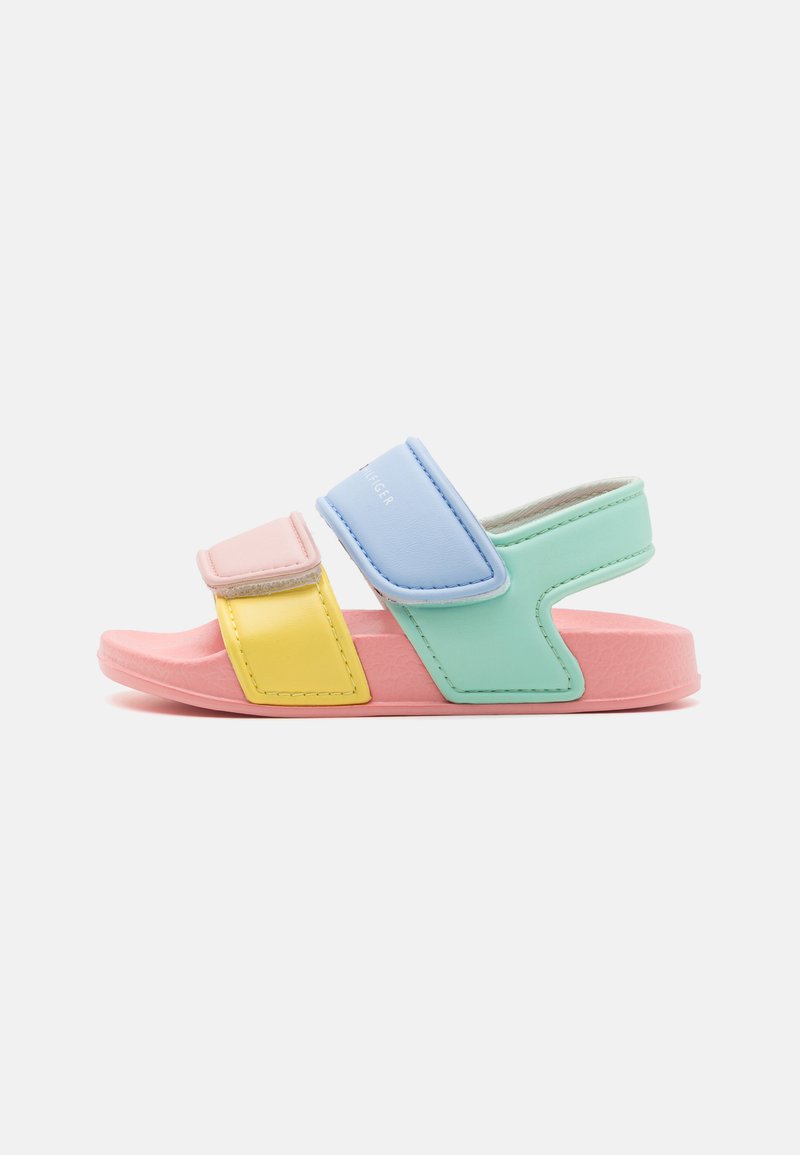 Bunte Sandalen mit einer pinken Sohle, gelben, grünen und blauen Riemen aus glattem Material, ausgestattet mit Klettverschlüssen zur Anpassung.