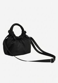 Petit sac à main noir avec tissu froncé, poignées courtes et rondes, et une longue bandoulière réglable sur un fond uni.