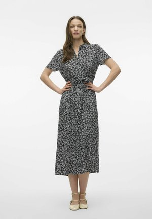 Robe noire à imprimé floral avec un col, des manches courtes et une ceinture à la taille. Longueur jusqu'au sol avec un bouton sur le devant. Texture de tissu lisse.