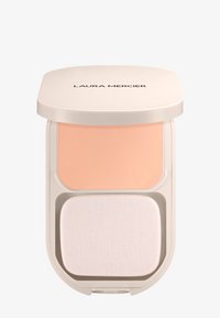 Base en polvo compacta beige con una esponja aplicadora blanca dentro de un estuche cuadrado de Laura Mercier en un tono beige claro y con bordes redondeados.